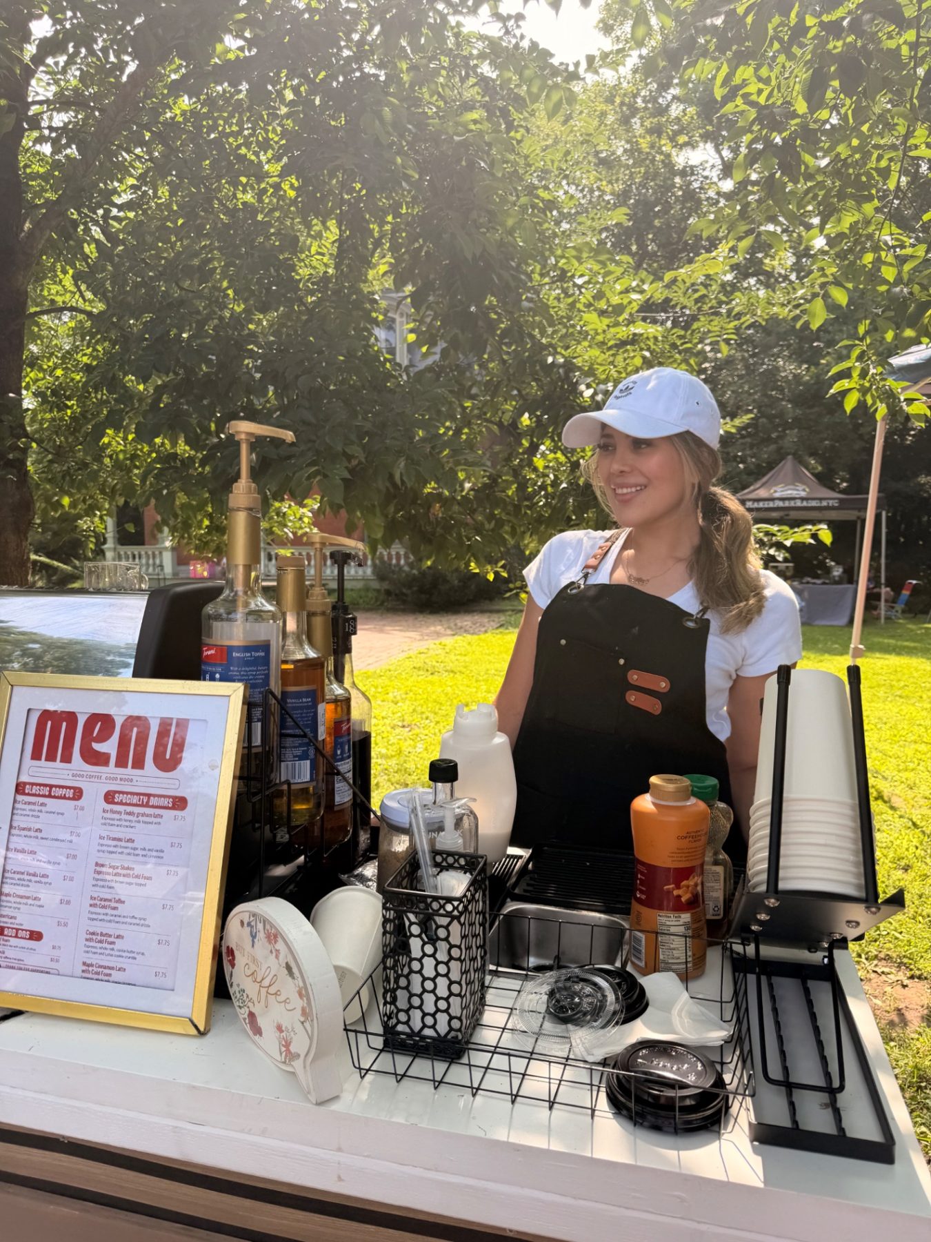 Close-up of the Ya Hala Coffee cart counter with the barista, menu, syrups, cups, and espresso equipment