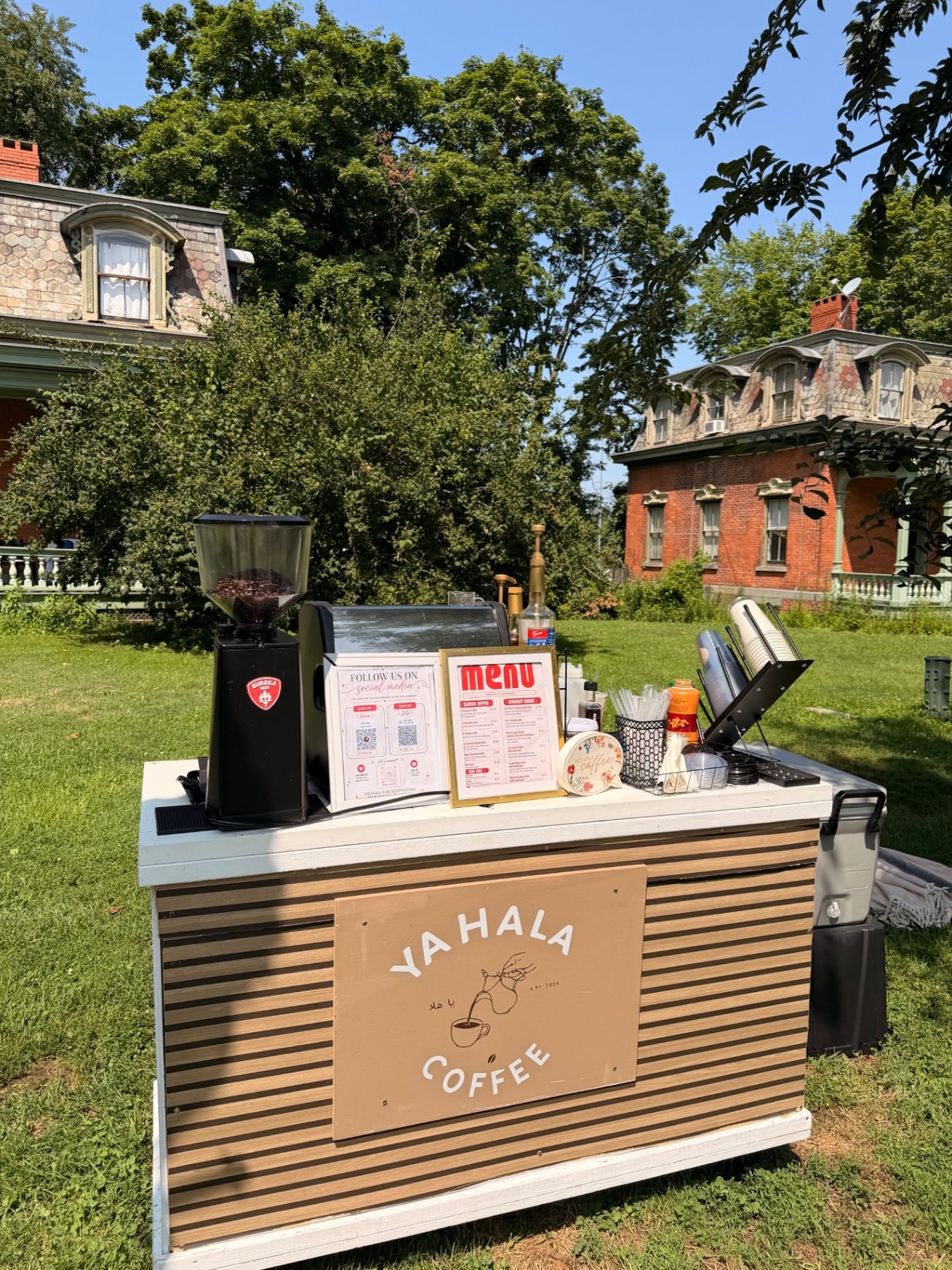 The Ya Hala Coffee cart set up on a lawn in front of historic buildings